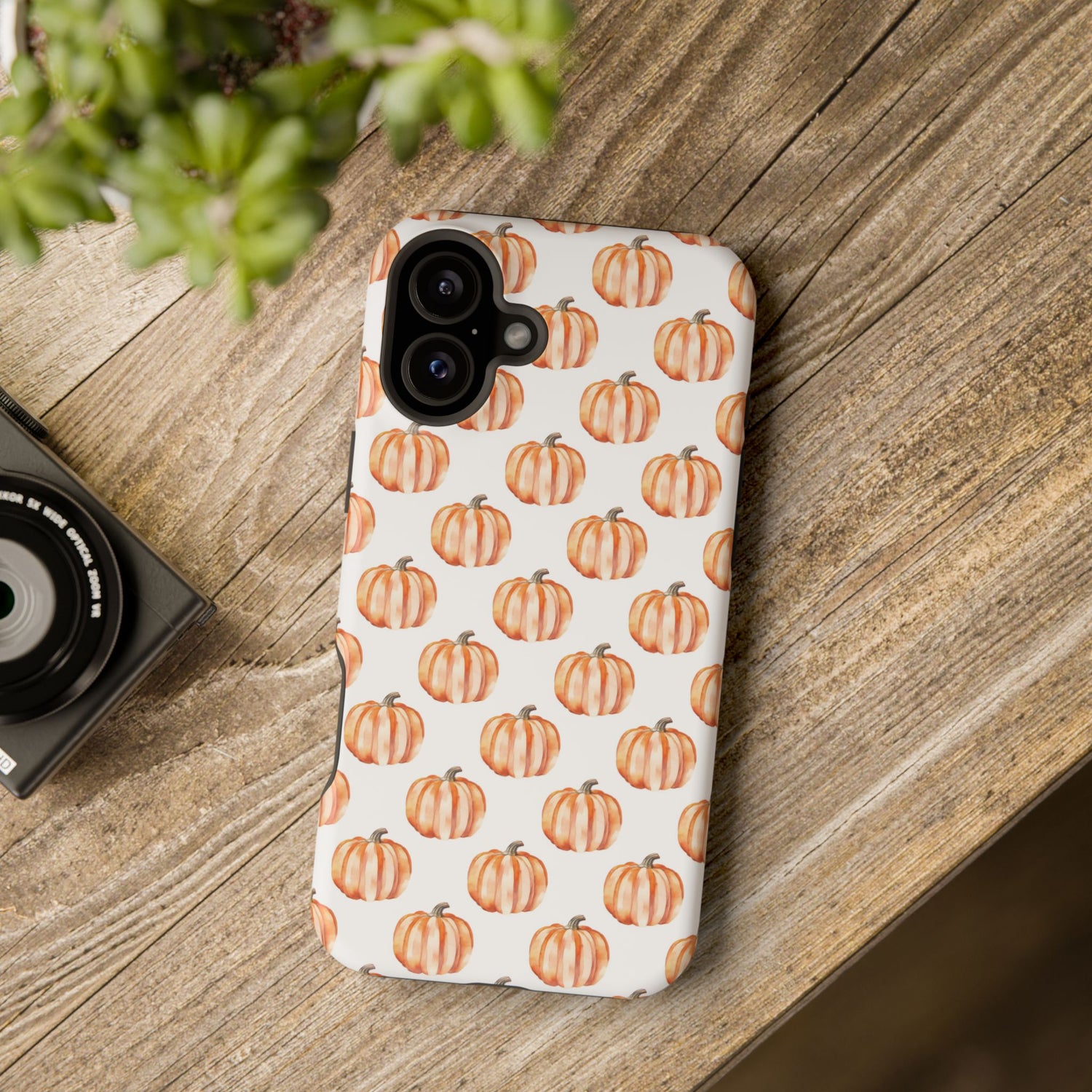 A phone case with a pattern of pumpkins on a white background, featuring a camera cutout and a black border at the top.