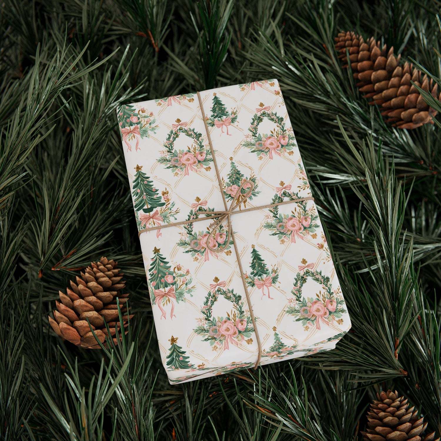 Pack of playing cards with floral and Christmas tree design on a bed of pine needles and pine cones.