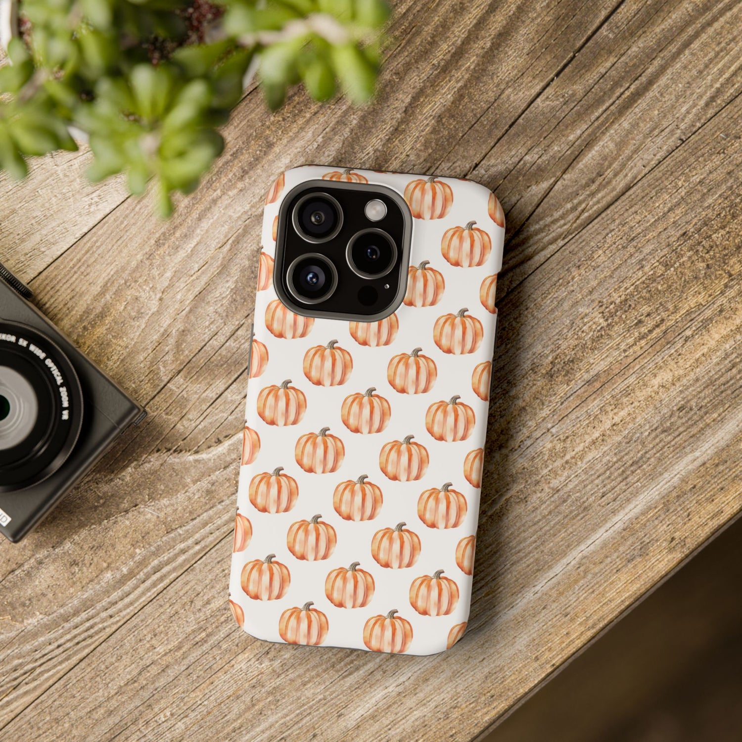 A phone case with a pattern of pumpkins on a white background, featuring a camera cutout and a black border at the top.