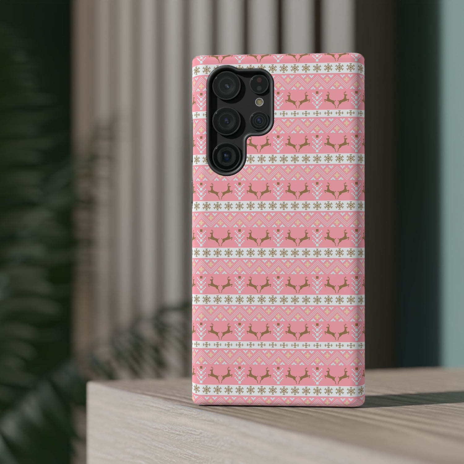 A pink Christmas-themed phone case with a pattern of deer antlers and stars, featuring a black removable TPU inner layer.