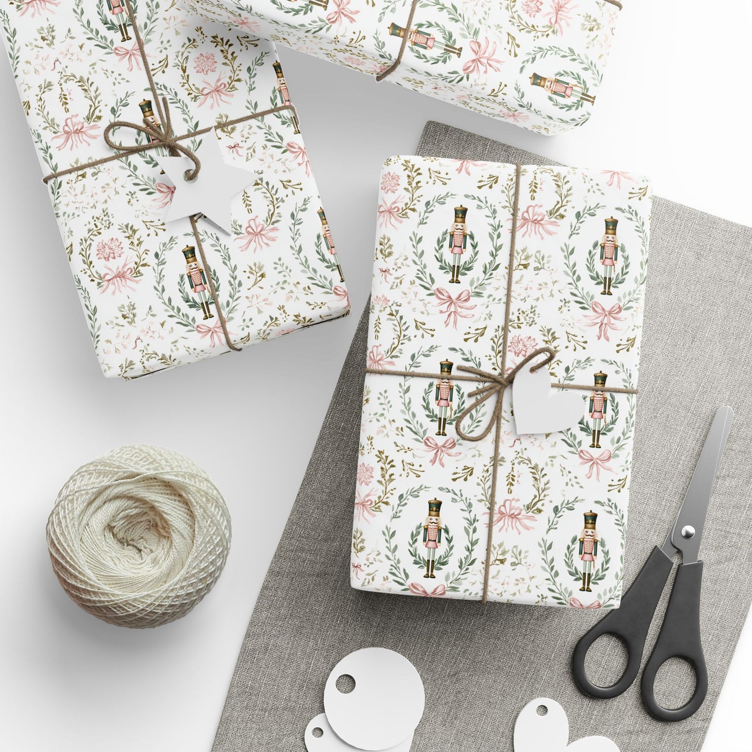 Gift boxes wrapped in festive paper with scissors and yarn on a light background