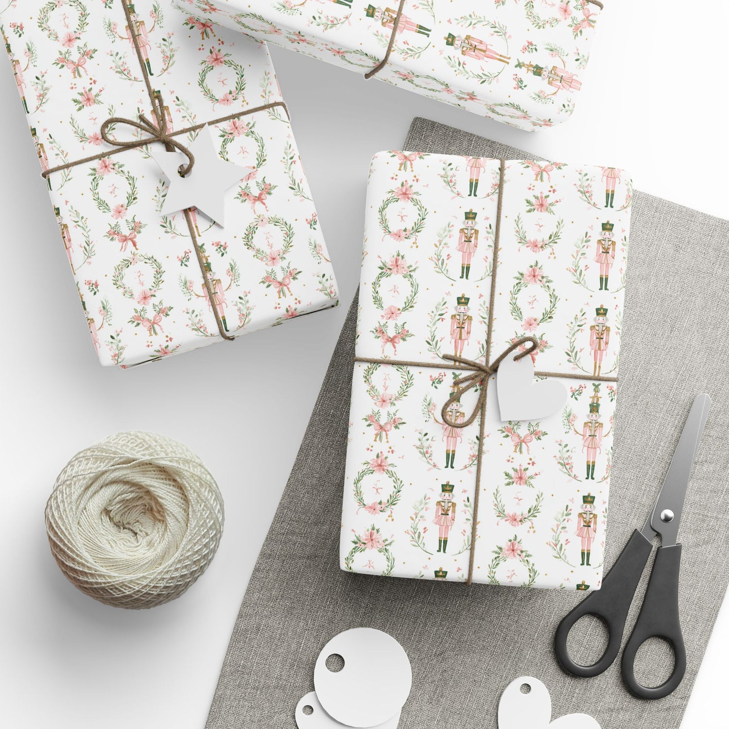 Gift boxes wrapped in festive paper with a ball of string and scissors on a light background