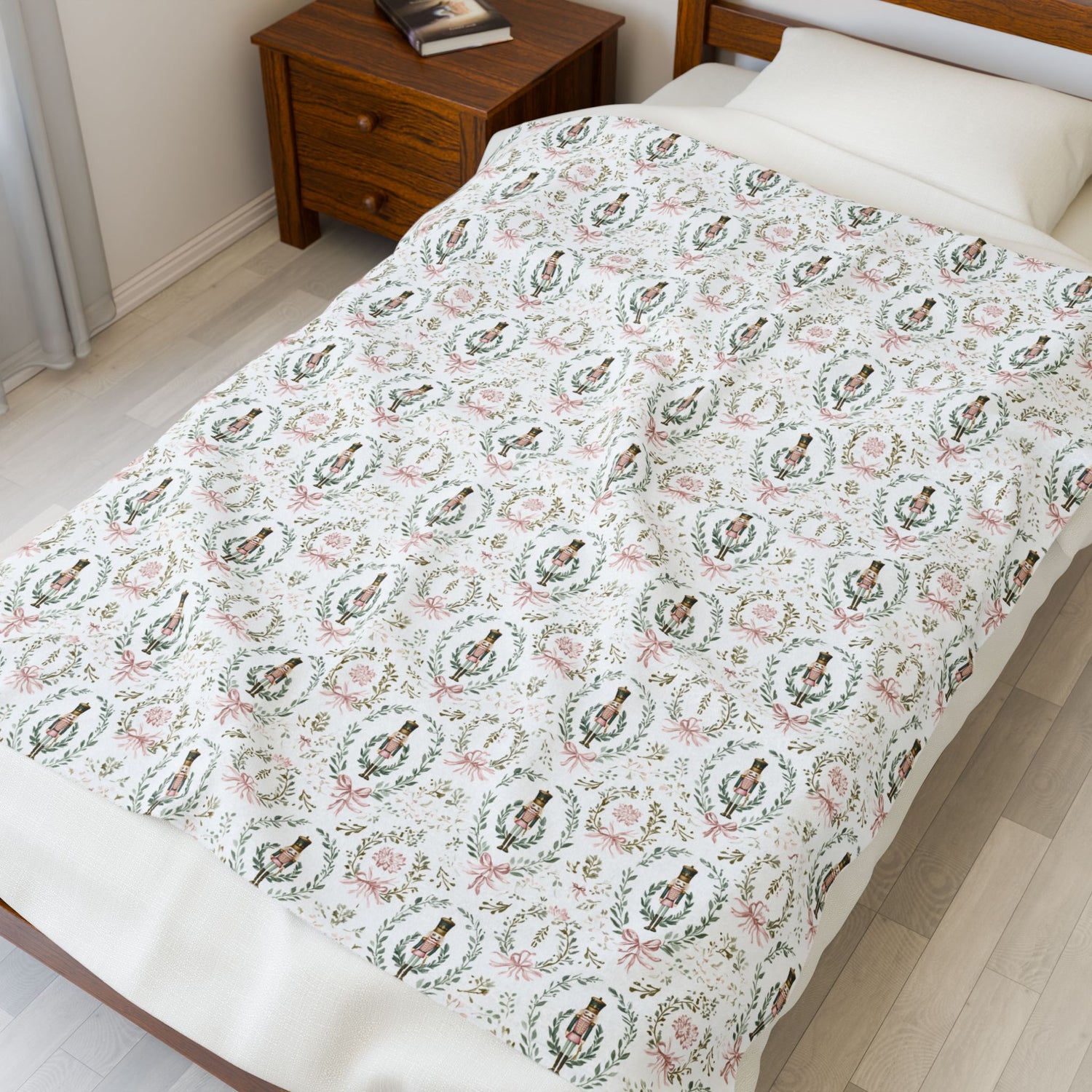 Bed with decorative bedding featuring a pattern of people in wreaths and flowers, next to a wooden nightstand.
