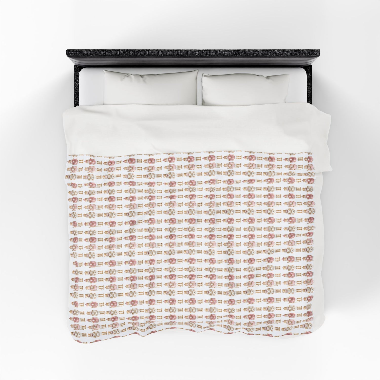 Bed with white bedding and a patterned pink and brown blanket on a white background