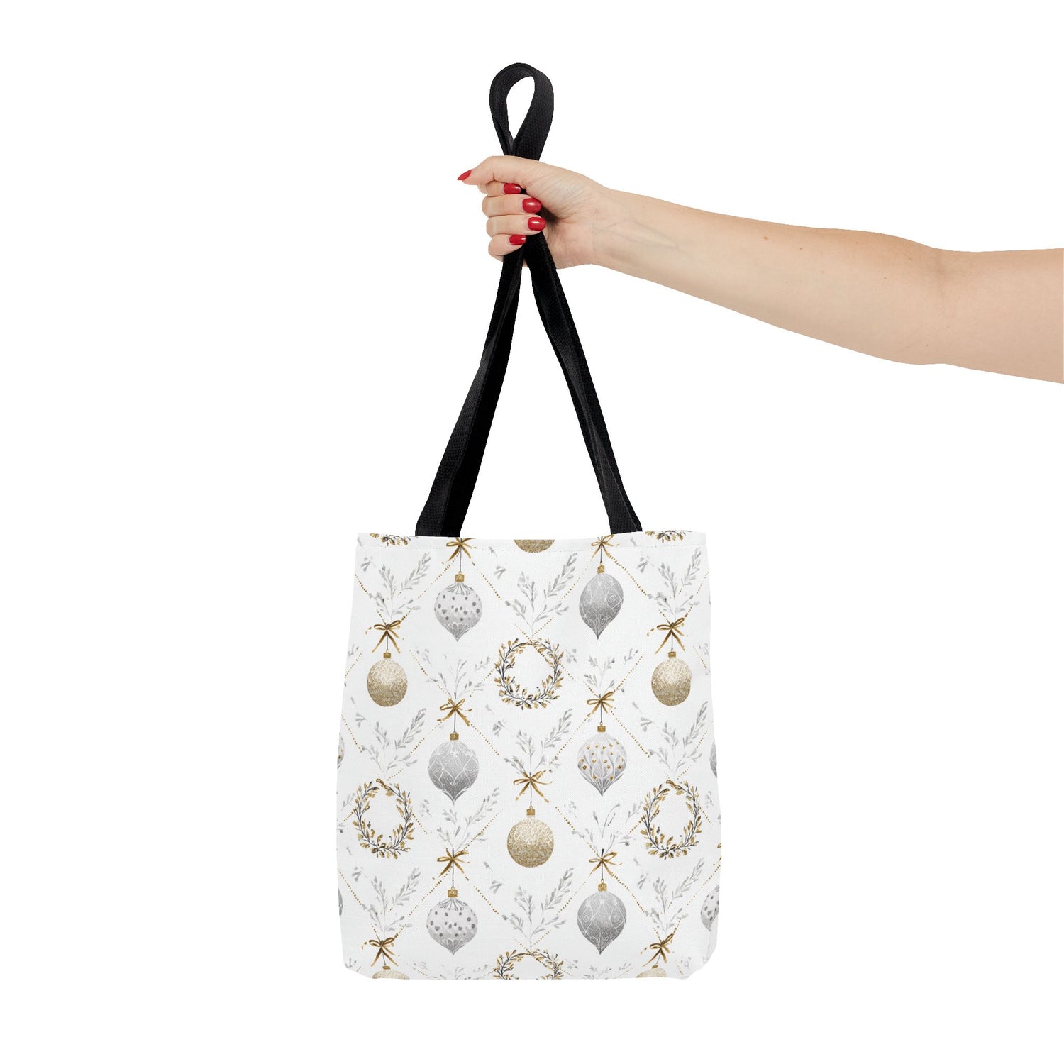 Tote bag with Christmas ornament pattern held by a hand on a white background