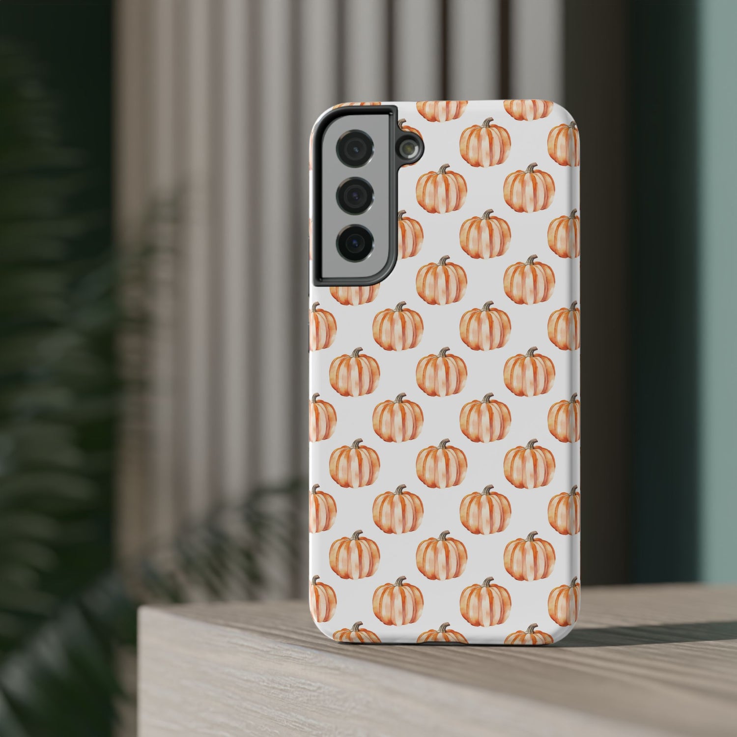 A phone case with a pattern of pumpkins on a white background, featuring a camera cutout and a black border at the top.