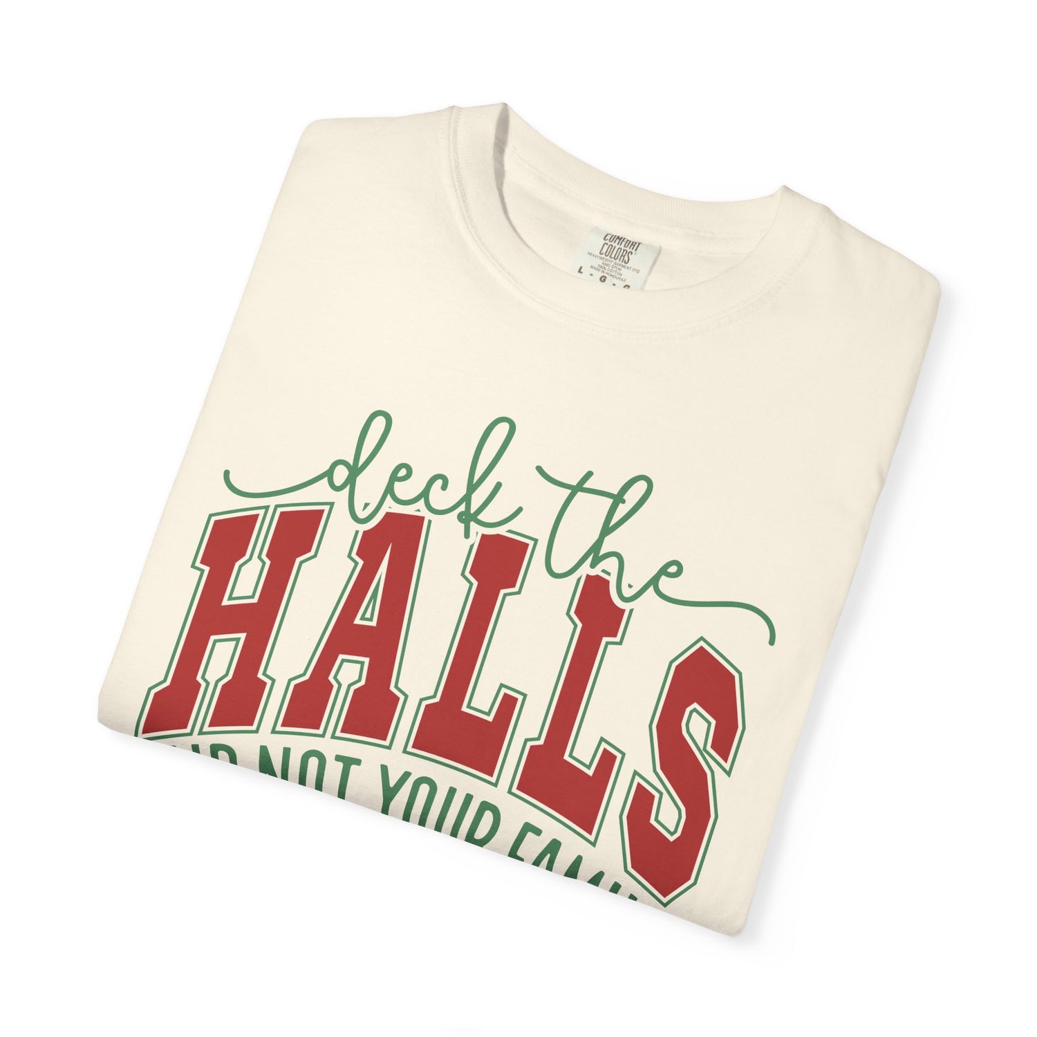 Folded cream-colored t-shirt with 'deck the HALLS' text in red and green on a white background