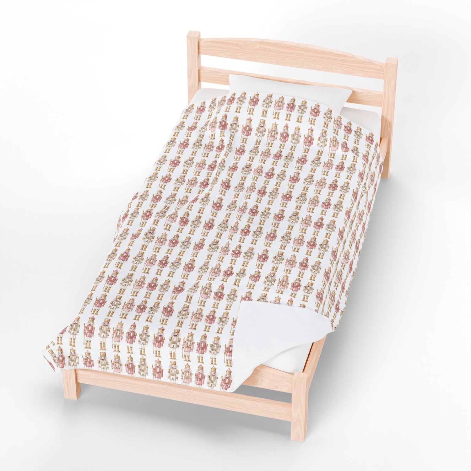 Patterned quilt on a wooden bed against a white background
