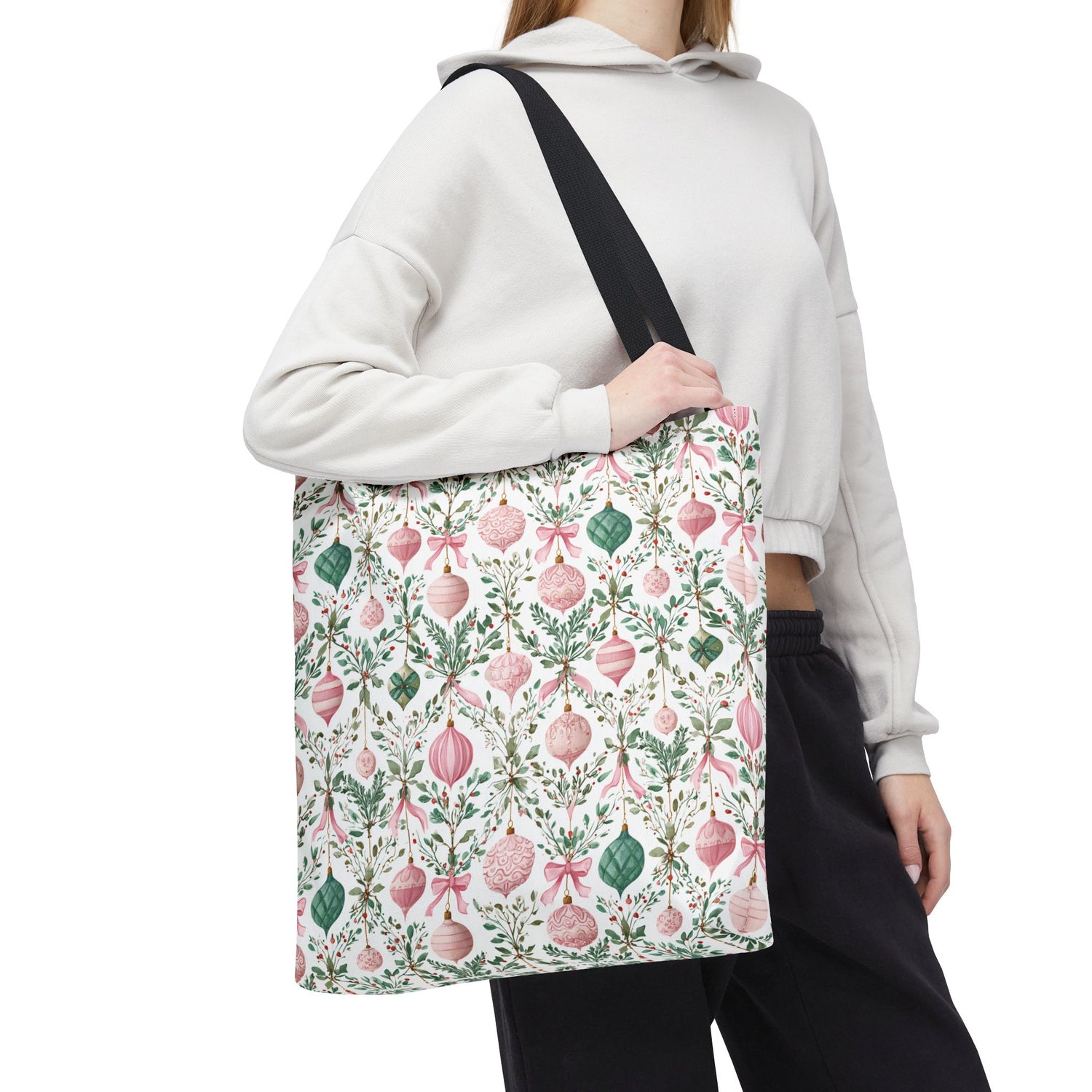 Person wearing a white hoodie with a floral-patterned bag over their shoulder on a white background