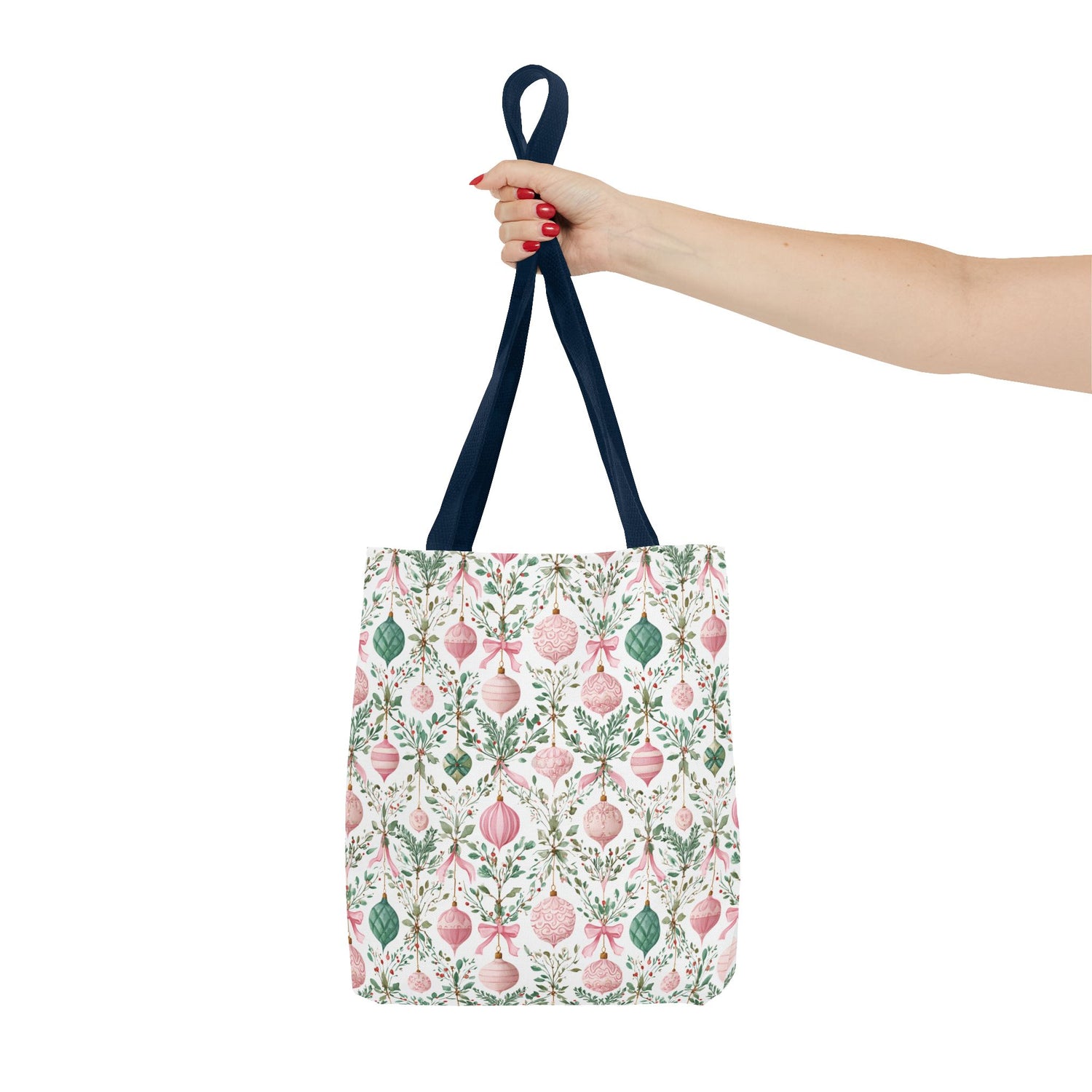Tote bag with floral and Christmas ornament pattern held by a hand on a white background