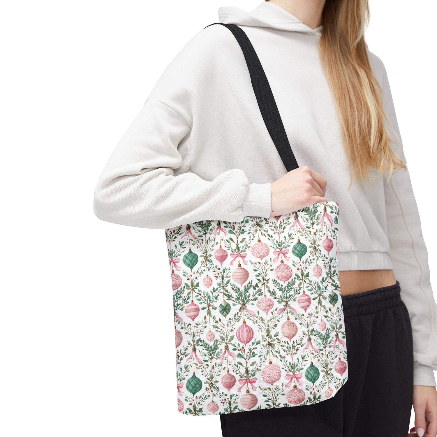 Person holding a floral-patterned tote bag against a white background