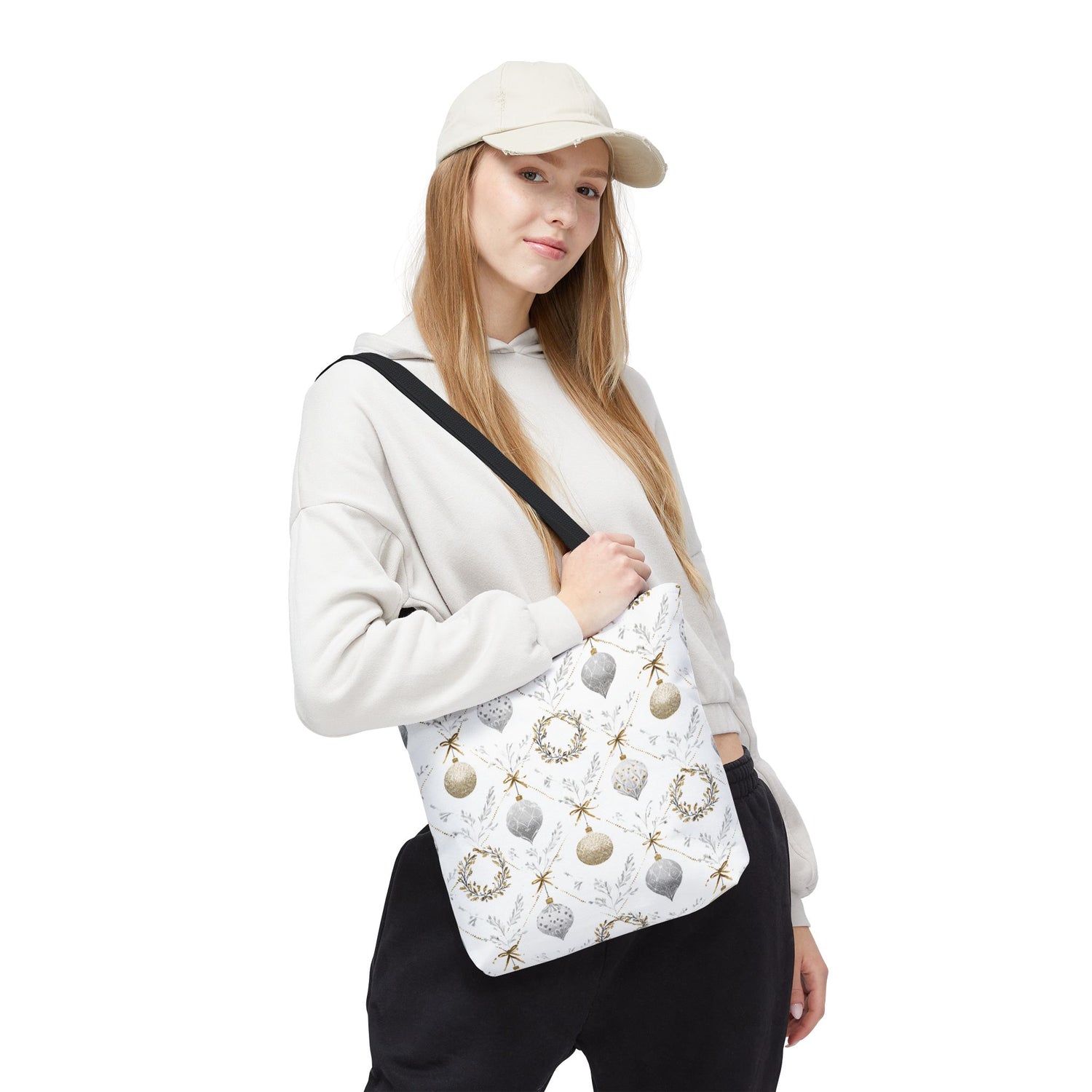 Person wearing a white cap and holding a patterned bag on a white background