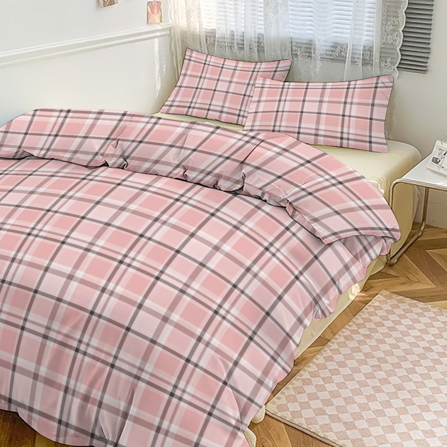 Pink plaid bedding set on a bed in a bedroom with a window in the background.